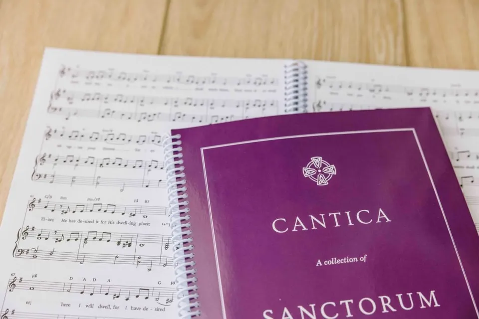 The Cantica Sanctorum hymnal open on a music stand